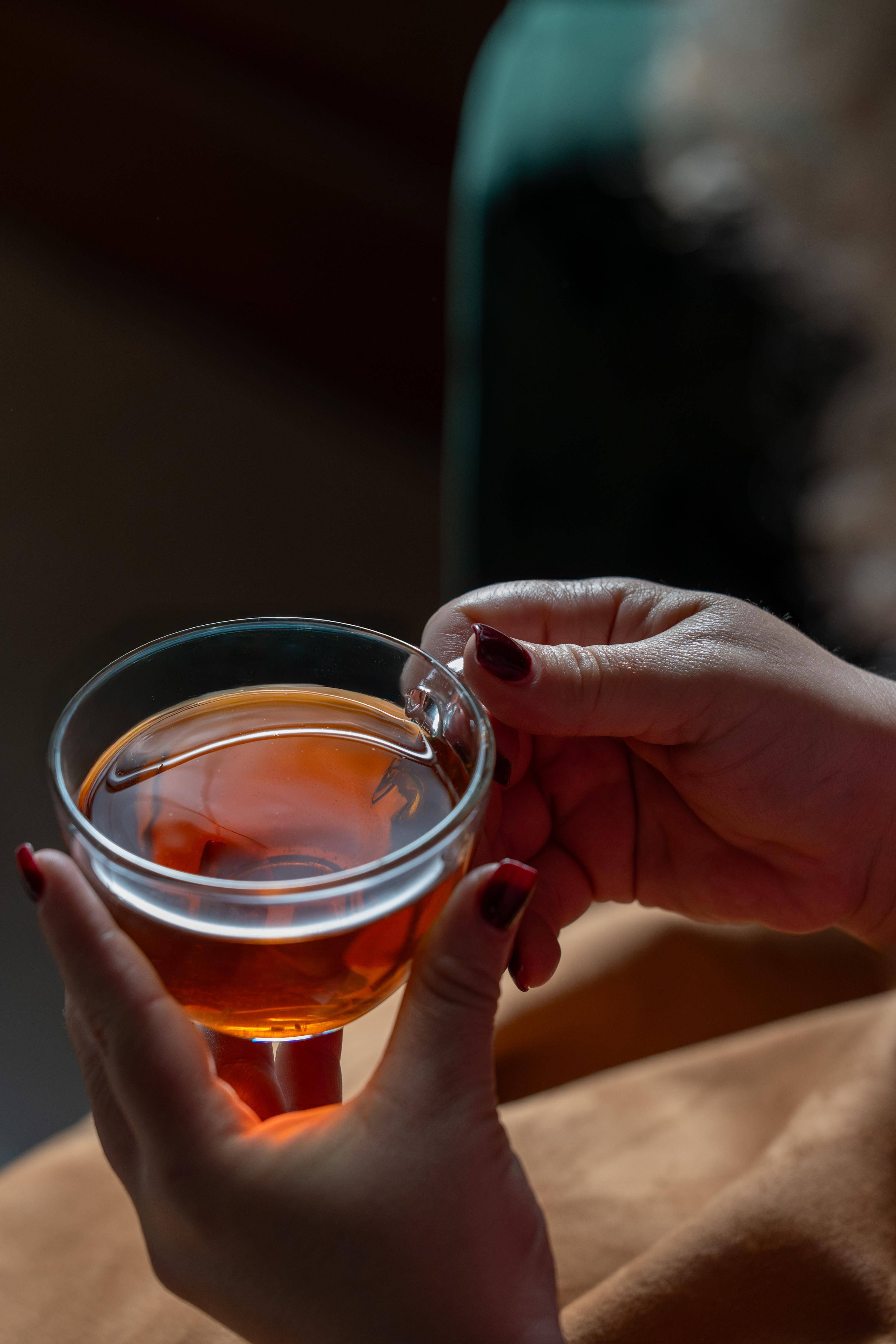 A cozy cup of Zabelia Evening Unwind Calming Rooibos Herbal Tea with a soft fabric cozy around the mug.